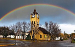 A rainbow over a church in a small town.