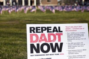 A sign that says repeal dad now in front of flags.