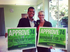 Two people holding up signs that say approve 4 for the freedom to marry for all.