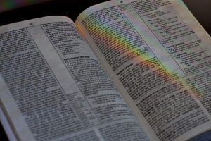 An open bible with a rainbow on it.