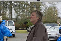 A woman is standing at a podium in front of a group of people.