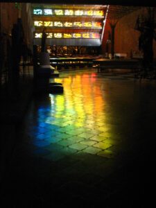 A stained glass window in a dark building.