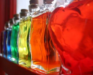 A row of colorful bottles on a window sill.