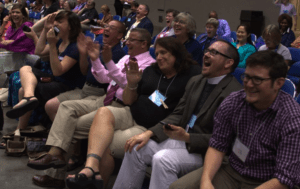 A group of people clapping at a conference.