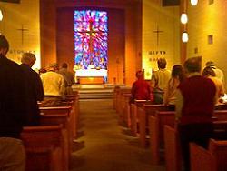 A group of people standing in a church with stained glass windows.