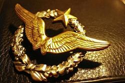 A badge with an eagle on it sits on top of a leather wallet.