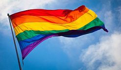 A rainbow flag flying in the sky.