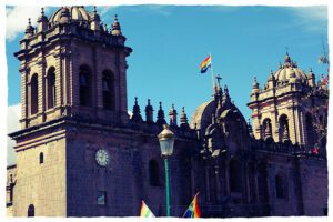 A church with a rainbow flag in front of it.