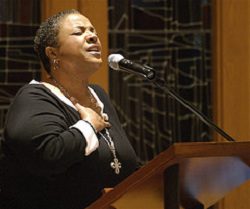 A woman singing into a microphone at a church.