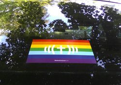 A car with a rainbow flag sticker on the back window.