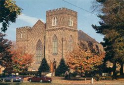 A photo of a church with trees in the background.