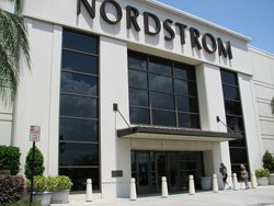 The entrance to a nordstrom store with palm trees in the background.