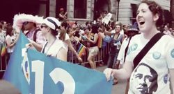 A group of people in a parade holding a banner.