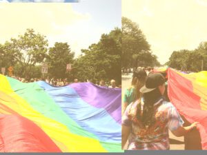 A group of people walking down a street with a rainbow flag.