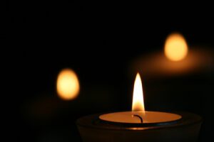 A group of candles are lit in the dark.