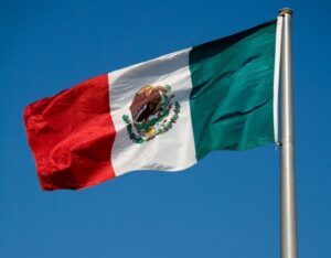 A mexican flag flying in the wind.