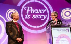 Two people standing at a podium with the words power is sexy.