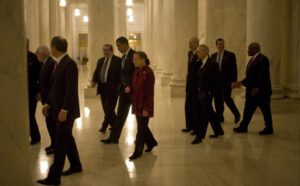 A group of people walking down a hallway.