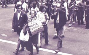 A group of people walking down a street with signs.