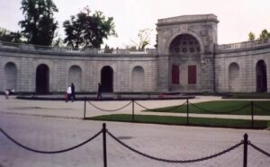 A large stone building with arches and a fountain.