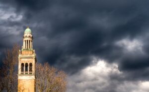 A clock tower under a dark cloudy sky.