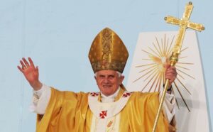 Pope john paul ii holds a golden cross.