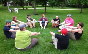 A group of people sitting in a circle on the grass.