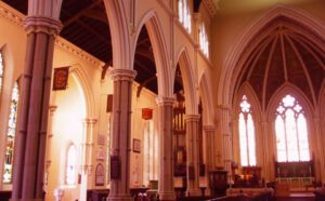 The inside of a church with pews and windows.