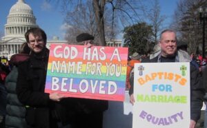 A group of people holding signs that say god has a baptist name for you.