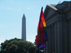 A rainbow flag in front of the washington monument.