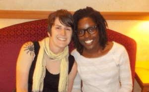 Two women posing for a photo in a hotel room.