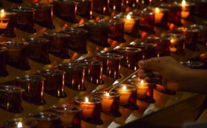 A person lighting a candle.