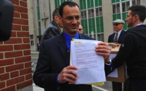 A man in a suit holding a piece of paper.