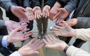 A group of people with their hands in a circle.