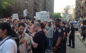 A crowd of people holding signs on a street.