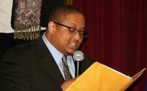 A man in a suit and tie reading a book.