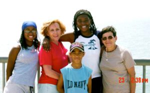 A group of people posing for a picture near the ocean.