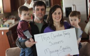 A family holding a sign that says this christian family supports marriage equality.