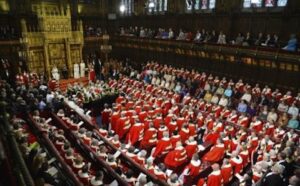 A large group of people in red robes sitting in a large room.