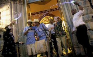 A group of people standing outside of a building with bubbles.