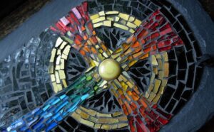 A mosaic tiled cross on a black background.