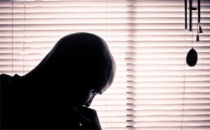 A silhouette of a man in front of a window.