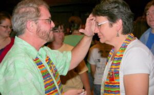 A man and woman are putting on a head scarf.