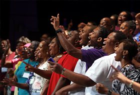 A group of people clapping in front of a stage.