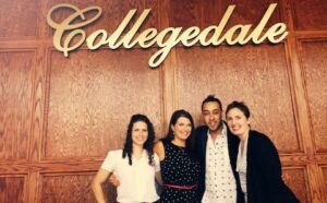 Four people posing in front of the collegedale sign.