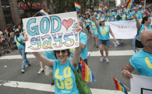 A group of people holding up a sign that says god is gay.