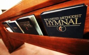 The united methodist hymnal on a wooden shelf.