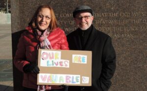 A man and woman holding a sign that says our lives are valuable.