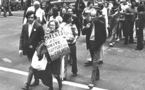 A group of people walking down a street with signs.