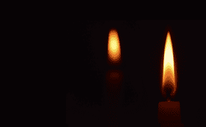Two lit candles on a black background.